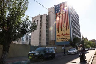 A man rides a motorbike past an anti-US mural on a building, amid a ceasefire between US and Iran, in Tehran, Iran, 22 April 2026